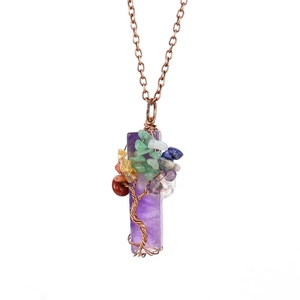 Macro shot of copper wire wrapped amethyst tree of life pendant with natural gemstone chips