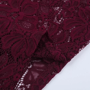 Detailed close-up of wine red lace fabric texture with intricate hollow-out floral patterns