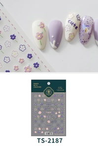 Dettaglio macro di adesivi per unghie 3D con fiori viola e scritte 'cute'