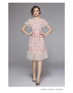 Détails de la robe en tulle rose avec broderies florales et jupe à plusieurs niveaux