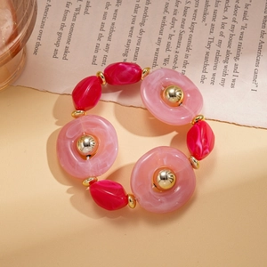 Detailed shot of pink acrylic rings and red irregular beads on a vintage book page