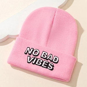Pink ribbed knit beanie with embroidered NO BAD VIBES slogan for a casual trendy look