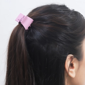 Pink matte small shark clip for high ponytail styling on brunette hair, rear view
