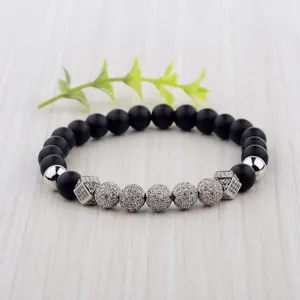 Matte black agate beaded bracelet with micro-pave zircon charms on wood background