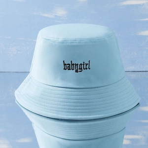 Dettaglio del ricamo babygirl su cappello bucket in twill di cotone azzurro con cuciture
