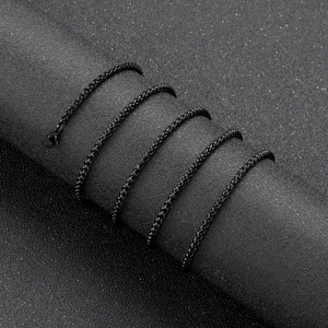Macro view of tight black titanium steel wheat chain links with a polished finish