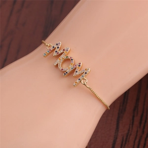 Close-up of gold MOM bracelet with colorful micro-pave zircons worn on a female wrist