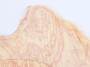 Dettaglio di abito in chiffon floreale con rifiniture in perline d'argento e spalline