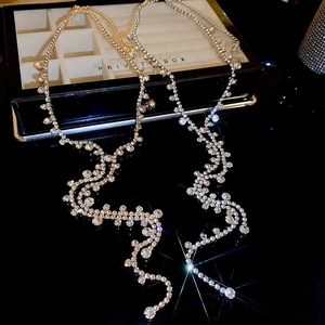 Close-up of sparkling rhinestone tassel necklaces in gold and silver luxury finishes