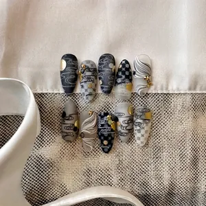 Artistic cloud pattern press-on nails with 3D wave textures in black, white, and gold