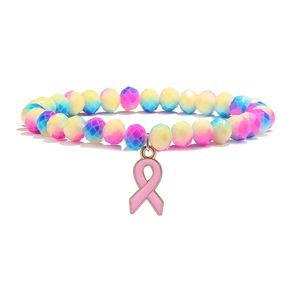 Détail macro de perles d'agate facettées multicolores et d'un pendentif ruban rose