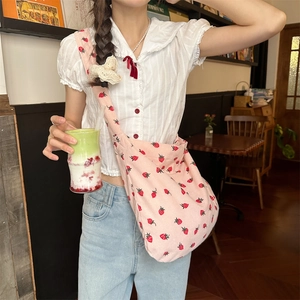Détail du sac à épaule en velours côtelé rose avec un motif d'imprimé fraise
