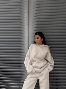 Women's oversized beige hoodie and jogger pants set shown in an outdoor street setting