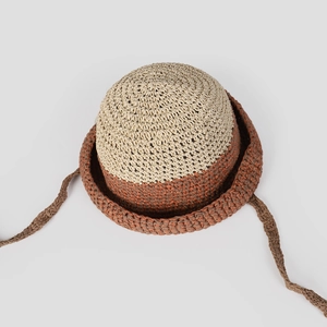 Vista detallada de un sombrero cloche de paja bicolor hecho a mano con cintas largas