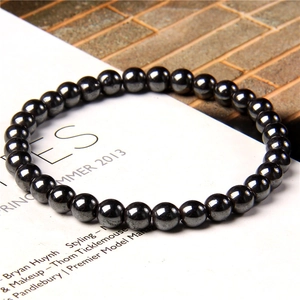 Macro shot of polished 6mm black natural stone beads on an elastic bracelet strand