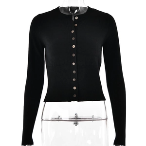 Detail of black knit cardigan showing ribbed cuffs and small button-down closure