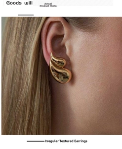Close-up of gold irregular teardrop earrings with liquid metal texture on model
