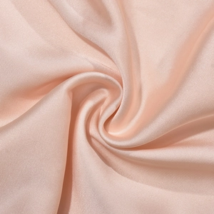 Détail macro du tissu satiné champagne brillant avec une texture plissée élégante