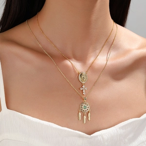 Gold layered necklace with emerald zircon feather pendant and virgin mary cross charms