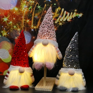 Three glowing Christmas gnomes with LED lights and sequined hats in red, pink, and gray colors
