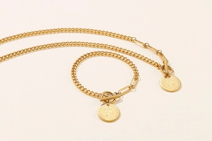 Close-up of gold Cuban link jewelry set with T-bar clasp and Elizabeth II coin pendant
