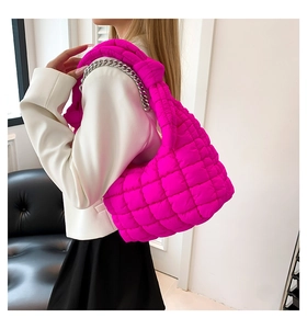 Detailed view of magenta quilted cloud bag with silver chain and knot shoulder strap