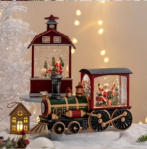 Detailed view of LED glowing Christmas snow globe set with vintage train and red barn decor