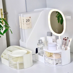 White vanity organizer with LED mirror and drawers for makeup storage on a desk