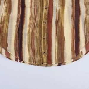 Détail de l'ourlet de chemise à rayures multicolores avec boutons sur tissu léger
