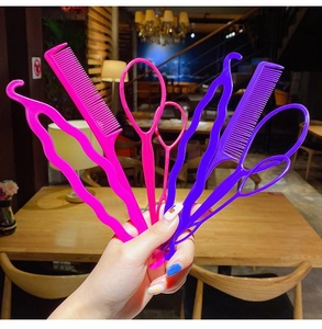 Close-up of 7-piece pink and purple plastic hair styling tools set held in hand