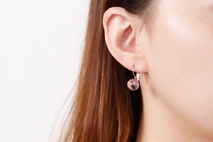 Detail of pink faceted crystal drop earrings with gold leverback closure on model
