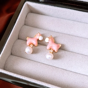 Detail of 18K gold-plated pony stud earrings with pink enamel and white pearls in a box