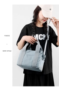 Detailed view of blue canvas handbag showing wide webbing handles and front pocket