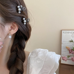 Close-up of elegant mini pearl hair claw and matching earrings on a female model
