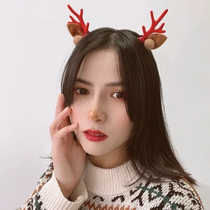 Cute Christmas reindeer antler headband with red antlers and gold bells worn by a model