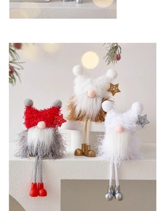 Close-up of three plush Christmas gnomes with long legs in a cozy festive home setting