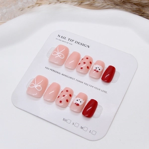 Cute pink and red press-on nails with cartoon dog patterns and elegant white bows