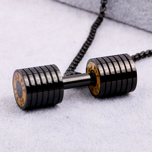 Close-up of black dumbbell pendant necklace with gold rings and GO FIT engraving