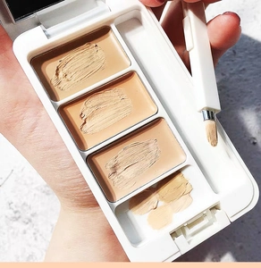 Nahaufnahme einer dreifarbigen Concealer-Palette mit einem tragbaren Make-up-Pinsel