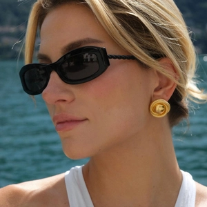 Golden 18k gold plated stainless steel textured round earrings on a female model