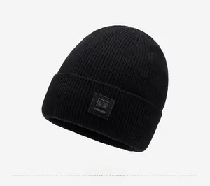 Detailed side view of black ribbed knit beanie with stylish square logo patch