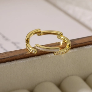 Close-up of gold geometric multi-layer ring with white enamel and micro-pave zircons