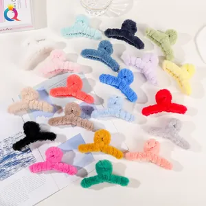 Multiple colors of large plush hair claws displayed with aesthetic lifestyle props