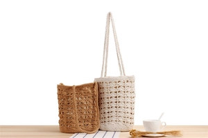 Detail of bohemian hollow-out crochet bucket bags in cream and brown on wooden table