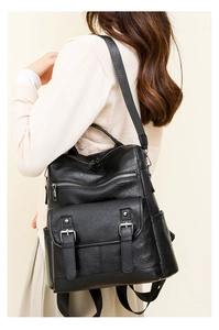 Detail of black soft PU leather backpack featuring silver hardware and multi-pocket design