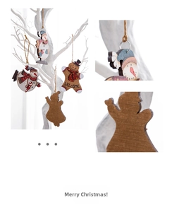 Close-up of wooden gingerbread man and snowman ornaments with hemp ropes on a white branch