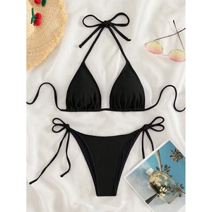 Black ribbed two-piece triangle bikini with side-tie bottoms on summer beach background