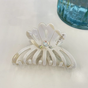 Detail of elegant cream marble acetate hair claw with sparkling rhinestones decoration