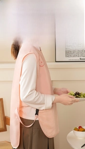 Detail of pink vest apron with adjustable side buckles and smiling face pattern