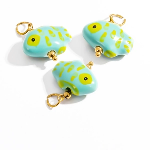 Detailed macro of three blue fish-shaped natural stone pendants with gold metal rings